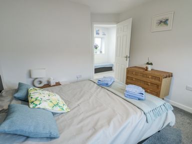 A bedroom with a bed and dresser at 16 Ffordd Meigan Beaumaris