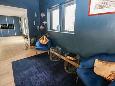 A living room with blue chairs and side tables at Chapel Hill in Catlowdy