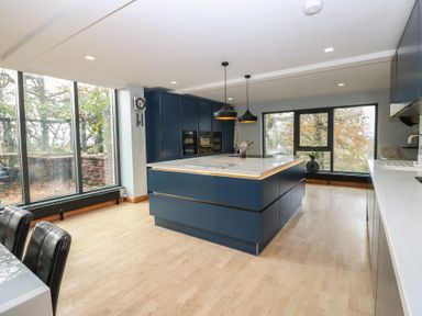 A kitchen with a central island and large windows at Chapel Hill in Catlowdy