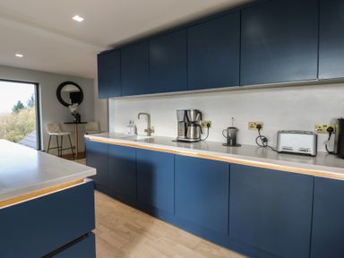 A kitchen with blue cabinets and appliances at Chapel Hill in Catlowdy