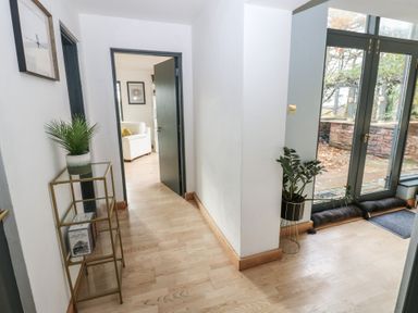 A hallway with a plant stand and doors at Chapel Hill in Catlowdy