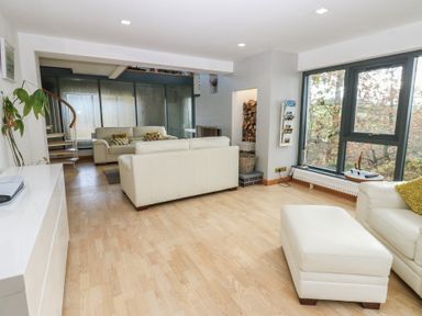 A living room with a sofa and windows at Chapel Hill in Catlowdy