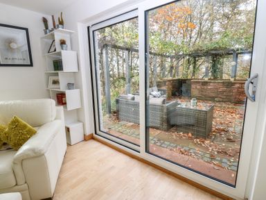 A living room with a sofa and a view of the patio at Chapel Hill in Catlowdy