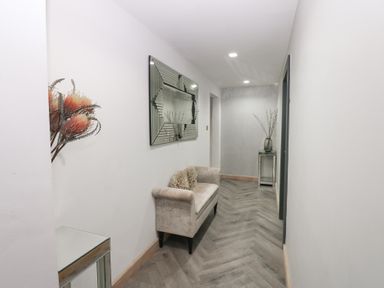 A hallway with a mirror and couch at Chapel Hill in Catlowdy
