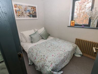A bedroom with a bed and wall art at Chapel Hill in Catlowdy
