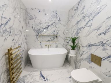 A bathroom with a bathtub, toilet and sink at Chapel Hill in Catlowdy