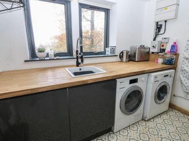 A kitchen with a sink and washing machine at Chapel Hill Catlowdy