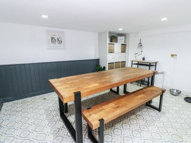 A dining room with a wooden table and benches at Chapel Hill, Catlowdy