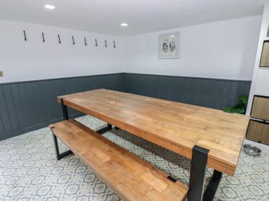 A dining room with a wooden table and benches at Chapel Hill in Catlowdy