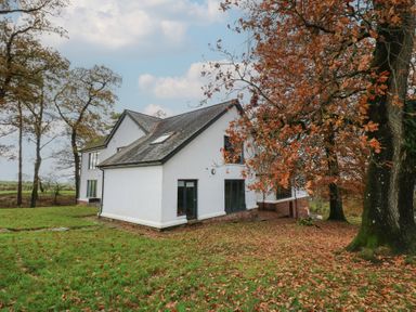 A house surrounded by trees and autumn leaves at Chapel Hill in Catlowdy