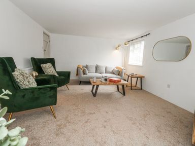 A living room with a sofa and two armchairs at Long Barn in Burton Bradstock