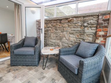 A seating area with two armchairs and a table at Long Barn in Burton Bradstock