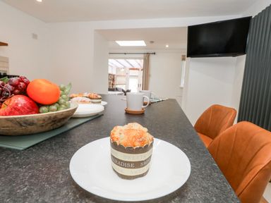 A kitchen with a table and fruit bowl at Long Barn in Burton Bradstock
