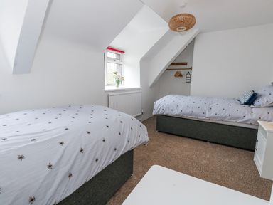 A bedroom with two beds and a window at Long Barn in Burton Bradstock