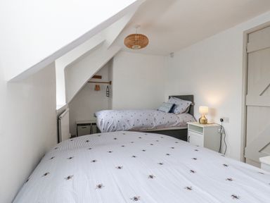 A bedroom with two beds and a lamp at Long Barn in Burton Bradstock