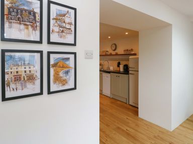 A kitchen with wall art and appliances at Long Barn in Burton Bradstock