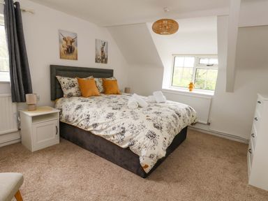 A bedroom with a bed and bedside table at Long Barn in Burton Bradstock