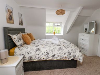 A bedroom with a bed and dresser at Long Barn in Burton Bradstock