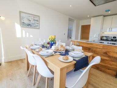 A dining room with a table set for a meal at Seafern House 36B Poole