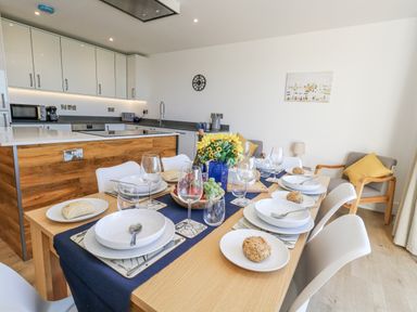 A dining room with a table set for dinner at Seafern House 36B in Poole