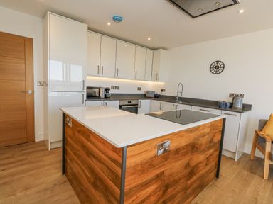 A kitchen with a kitchen island and cabinets at Seafern House 36B in Poole
