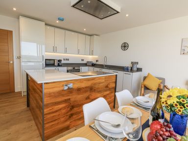 A kitchen with a dining table and kitchen island at Seafern House 36B Poole