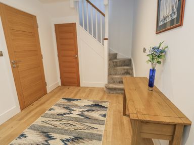 A hallway with a staircase and console table at Seafern House 36B, Poole