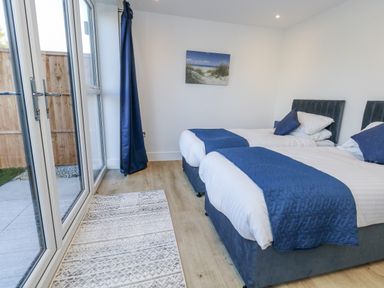A bedroom with twin beds and a large window at Seafern House 36B Poole