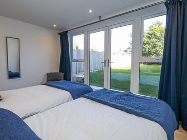 A bedroom with twin beds and a sliding door at Seafern House 36B Poole