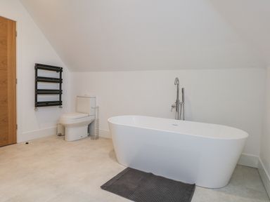 A bathroom with a bathtub and toilet at Seafern House 36B Poole