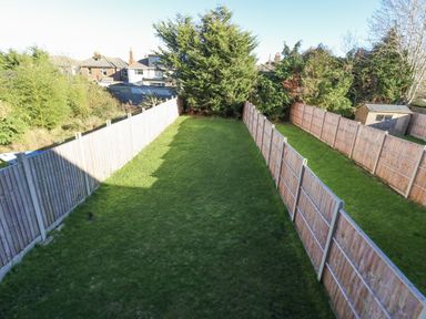 A garden with grass and fences at Seafern House 36B in Poole