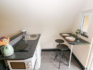 A kitchen with a stove and sink at Cwtch Bach in Aberdare