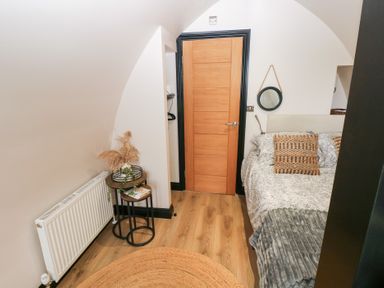 A bedroom with a bed and side table at Cwtch Bach in Aberdare