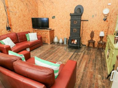 A living room with a sofa and fireplace at Cwtch Bach in Aberdare