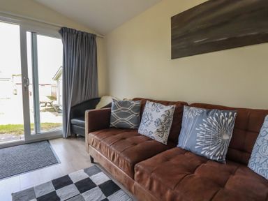 A living room with a sofa and pillows at Stanbury in St Merryn
