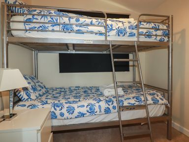 A bunk bed with patterned bedding and a lamp at Stanbury in St Merryn