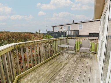 A deck with table and chairs at Peaceful in Stranraer