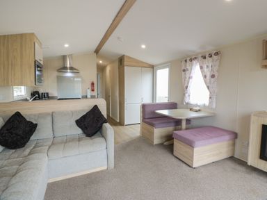 A living room with a sofa and dining table at Peaceful in Stranraer