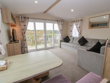A living room with a sofa and television at Peaceful in Stranraer