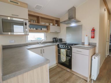 A kitchen with a stove and microwave at Peaceful in Stranraer