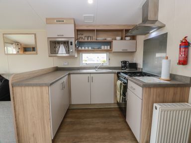 A kitchen with sink, oven, and microwave at Peaceful in Stranraer