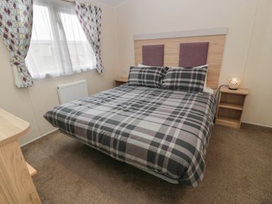 A bedroom with a bed and bedside table at Peaceful in Stranraer
