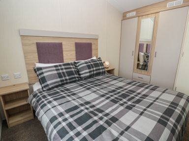 A bedroom with a double bed and wardrobe at Peaceful in Stranraer
