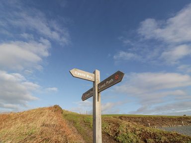 A signpost indicating directions to Castle Bay and Coast Path at Peaceful in Stranraer