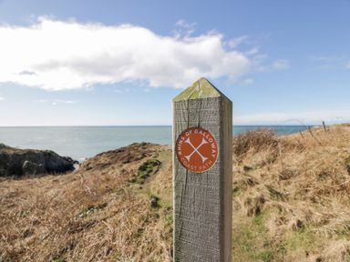 A signpost for Rhins of Galloway Coast Path near the ocean at Peaceful in Stranraer
