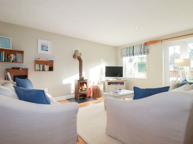 A living room with a stove and television at The Mizzen in St Endellion near Port Isaac