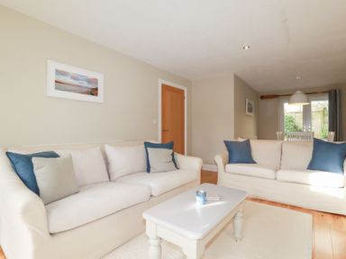A living room with sofas and a coffee table at The Mizzen in St Endellion near Port Isaac