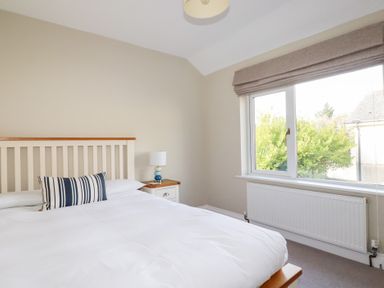 A bedroom with a bed and window at The Mizzen St Endellion near Port Isaac