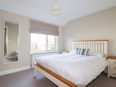 A bedroom with a bed and bedside table at The Mizzen St Endellion near Port Isaac