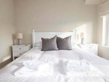 A bedroom with a bed and bedside tables at The Mizzen in St Endellion near Port Isaac